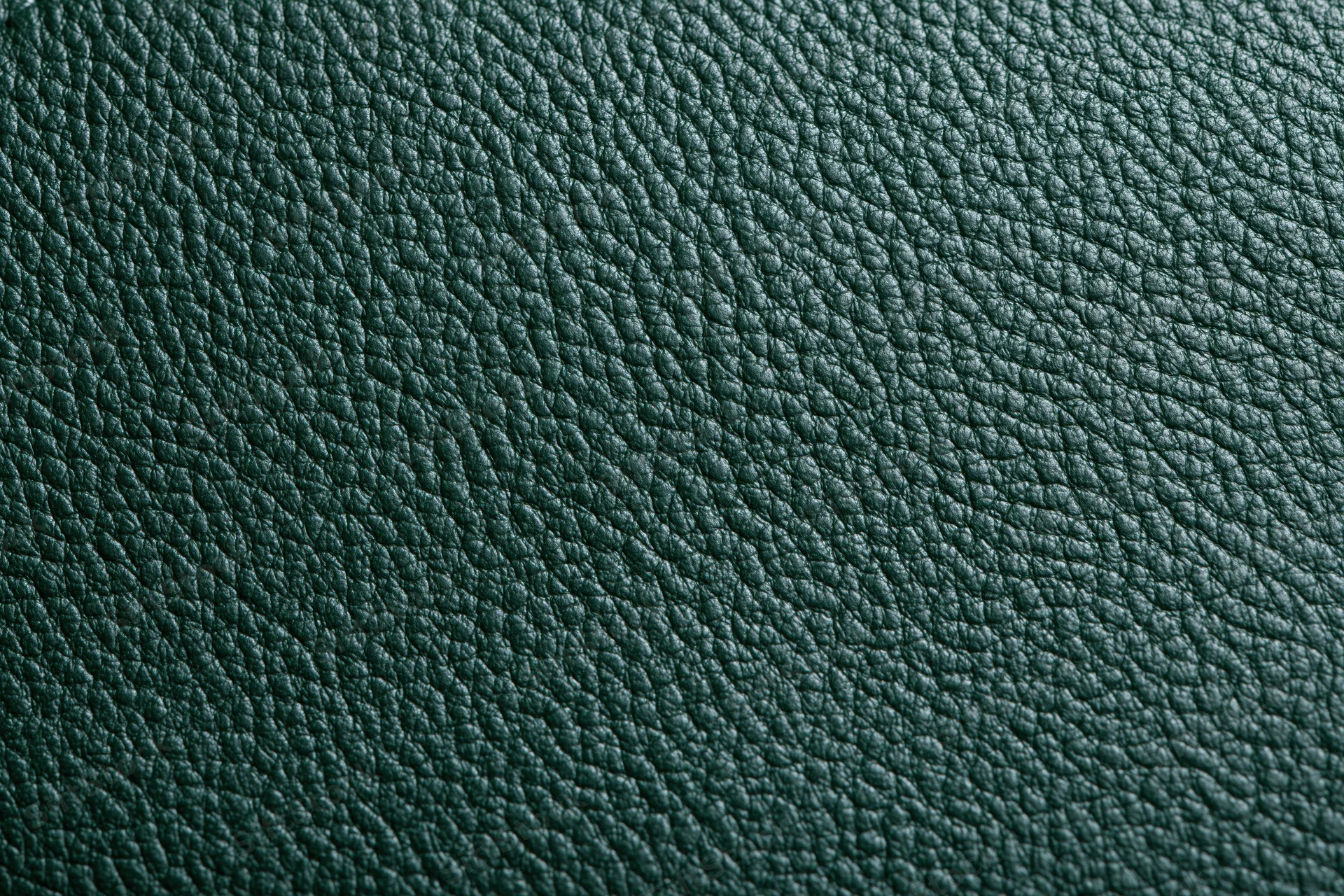 Close-up of dark forest green leather surface showing pebbled texture and grain pattern