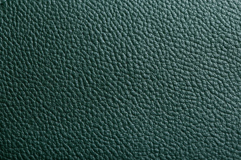 Close-up of dark forest green leather surface showing pebbled texture and grain pattern