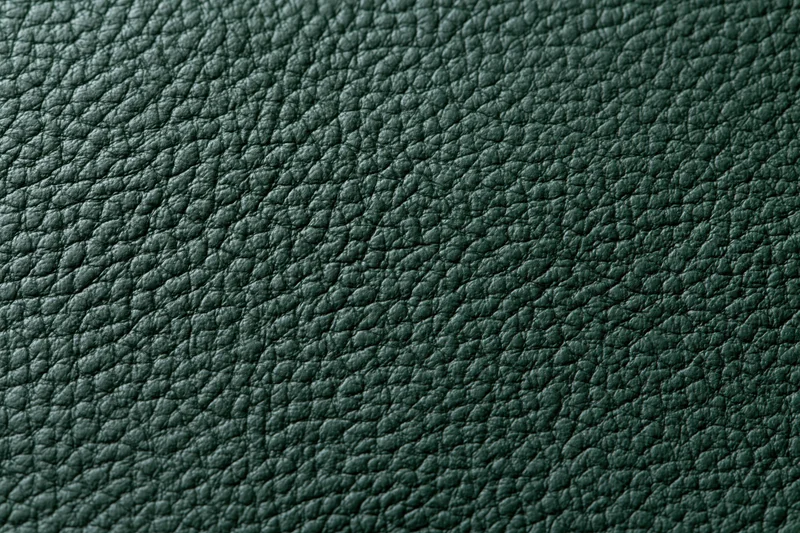 Close-up of dark forest green leather surface showing pebbled texture and grain pattern