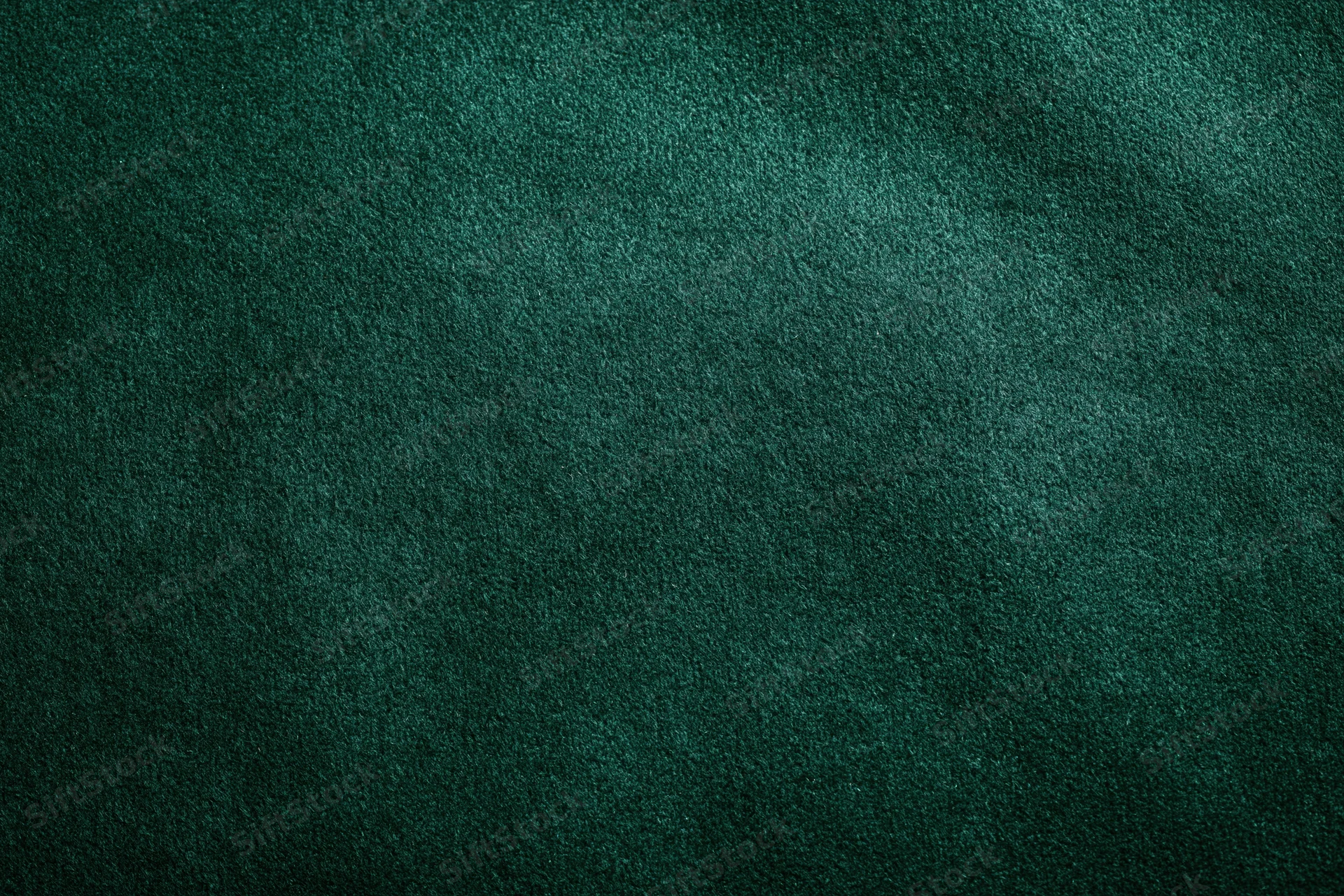 Close-up of dark forest green velvet or suede fabric surface