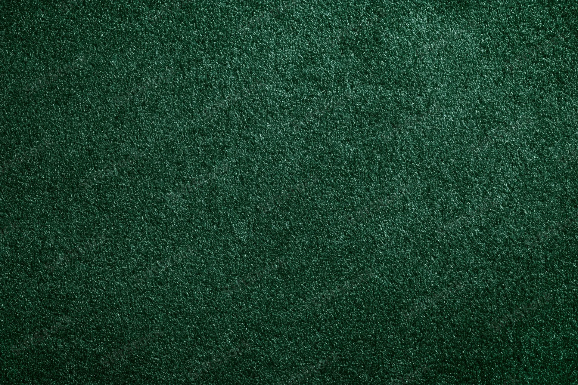 Close-up of dark forest green velvet or suede fabric surface