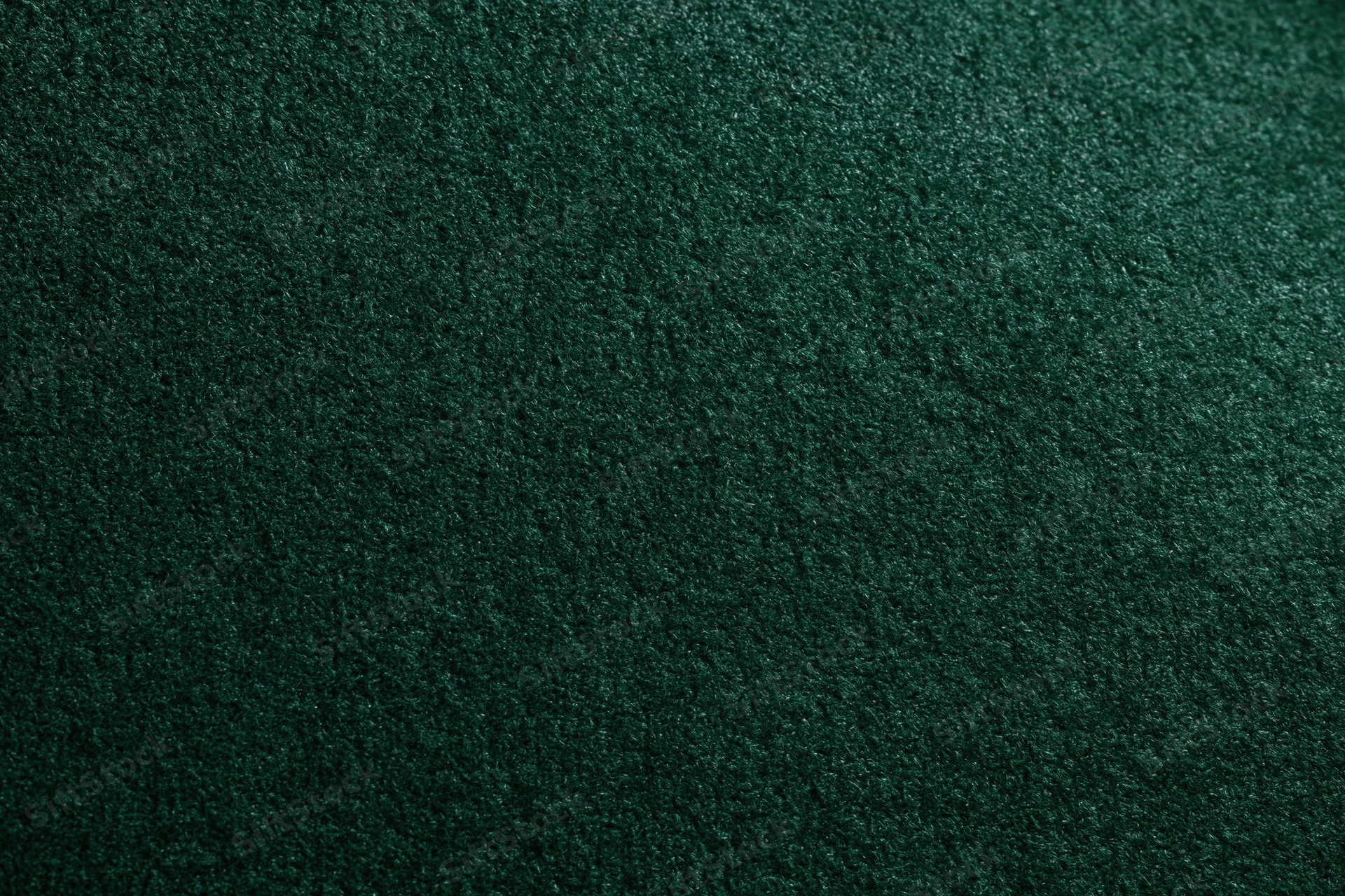 Close-up of dark forest green velvet or suede fabric surface