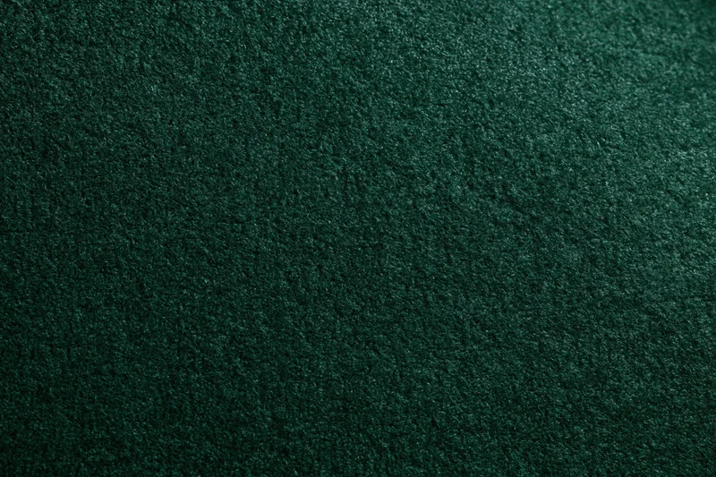 Close-up of dark forest green velvet or suede fabric surface