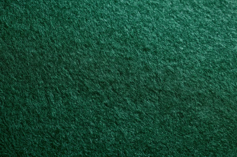 Close-up of dark green felt fabric surface filling the frame