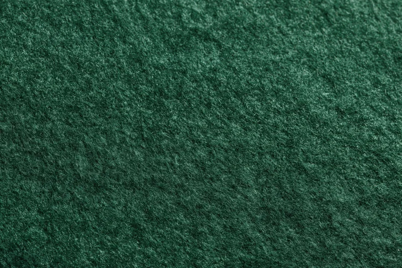 Close-up of dark green felt fabric surface filling the frame