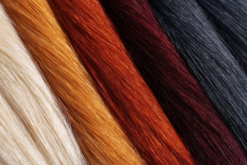 Close-up of five horizontal bands of hair color swatches arranged side by side