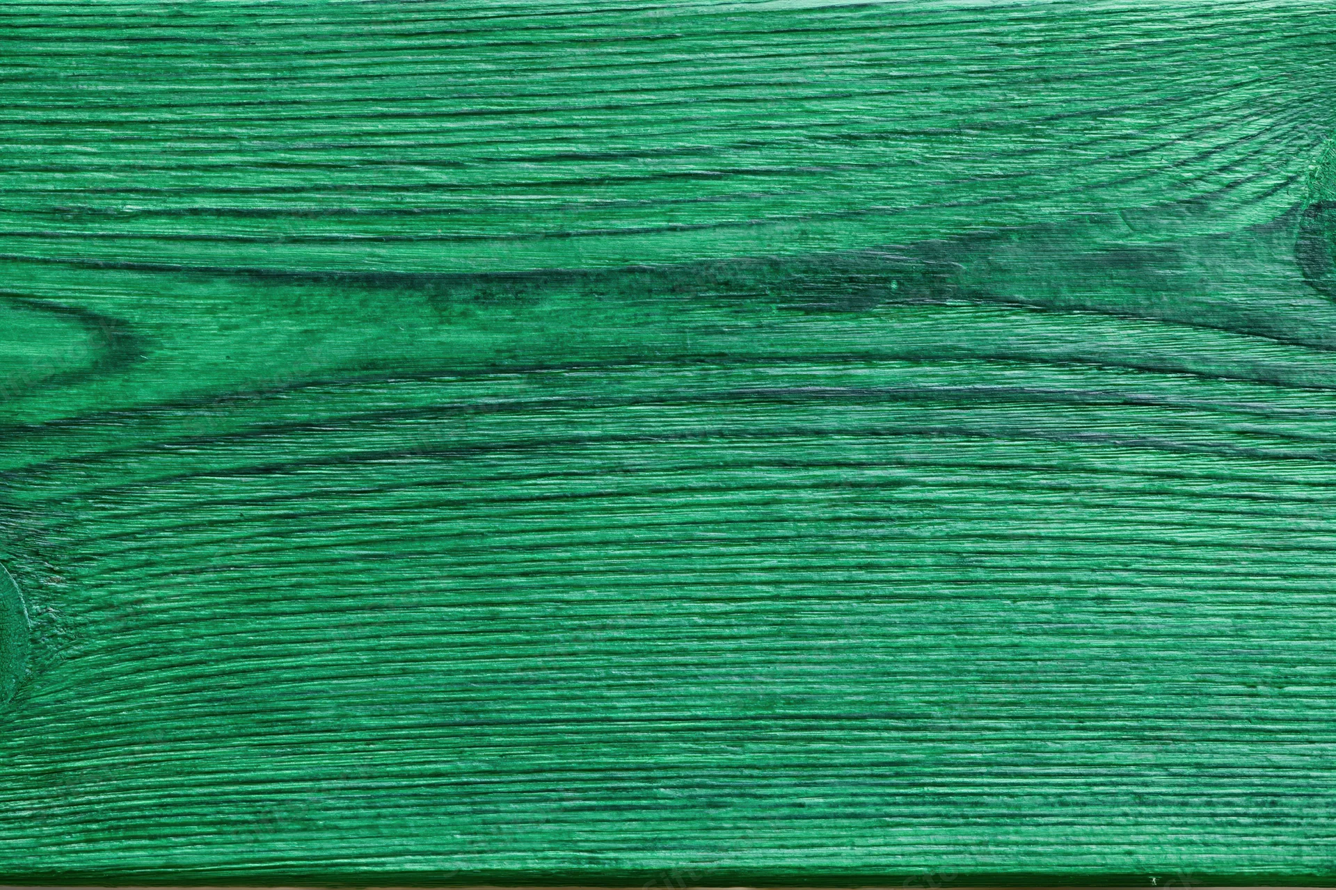 Close-up of green-painted wooden surface showing natural grain and texture