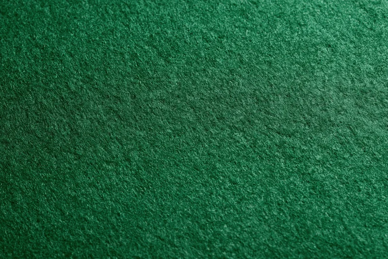 Close-up flat lay of green felt fabric surface filling the frame