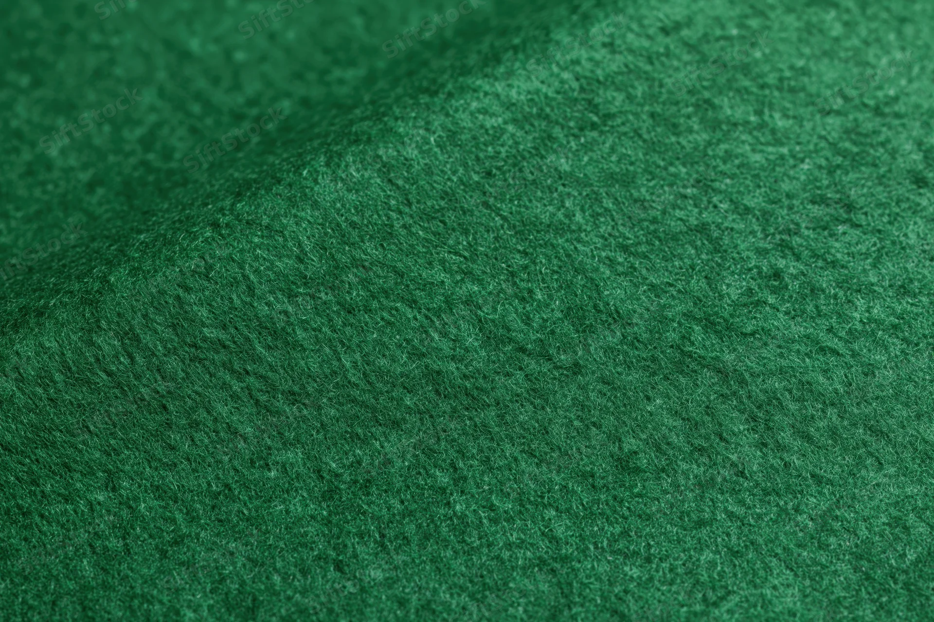 Close-up of green felt fabric surface with soft fibrous texture filling the frame