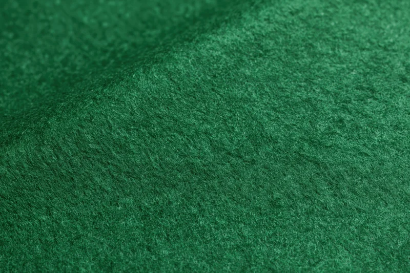 Close-up of green felt fabric surface with soft fibrous texture filling the frame