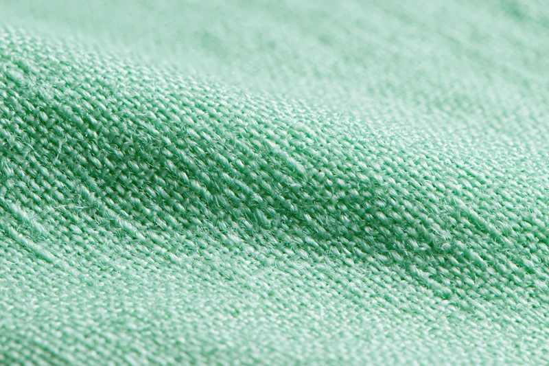 Close-up of light mint green woven fabric texture filling the frame