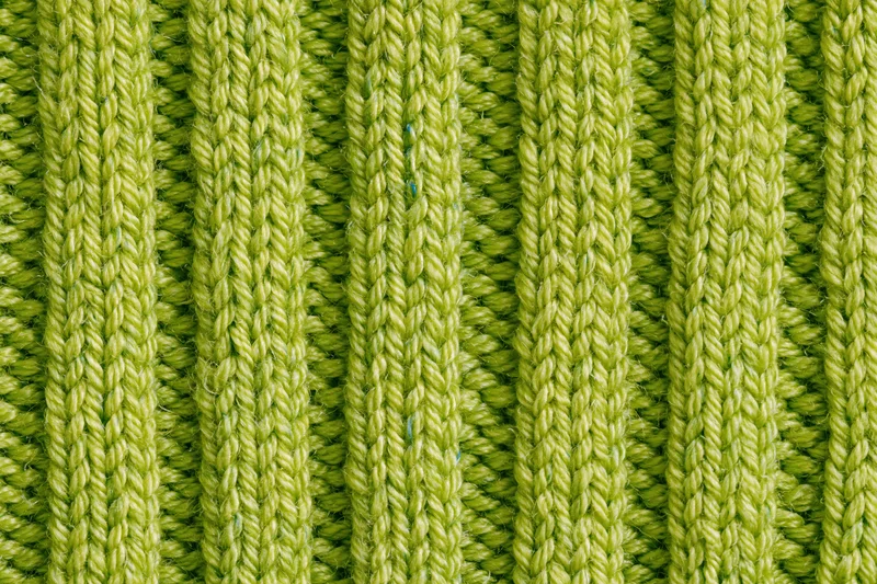Close-up of lime green ribbed knit fabric texture filling the frame