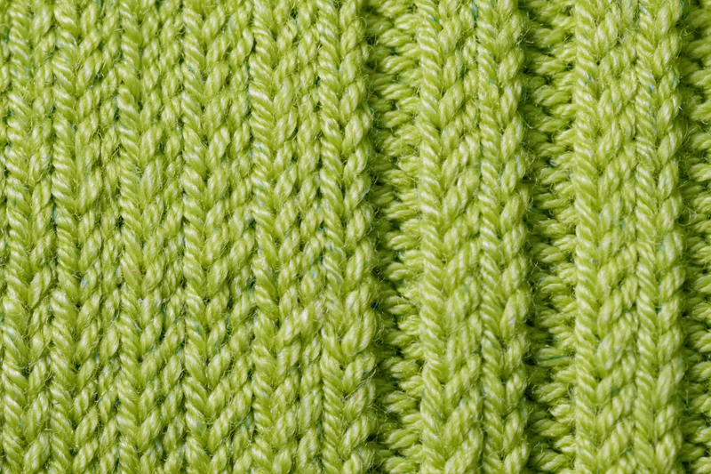 Close-up of lime green ribbed knit fabric texture filling the frame