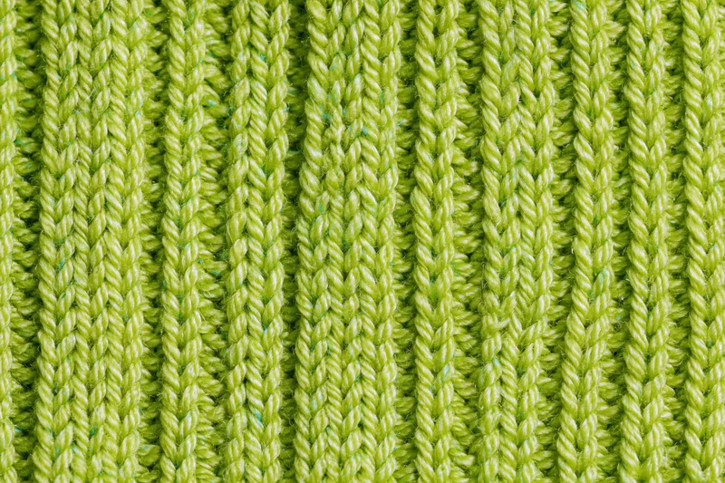 Close-up of lime green ribbed knit fabric texture filling the frame