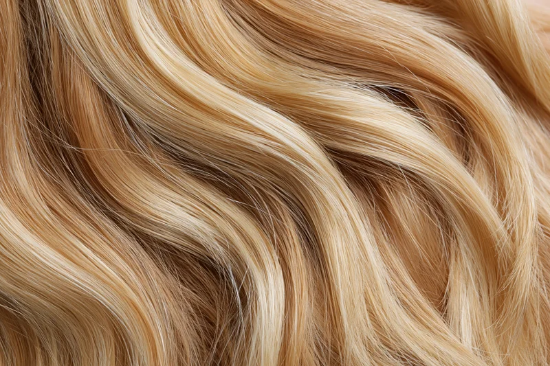 Close-up of loose wavy blonde hair filling the frame with natural texture and highlights