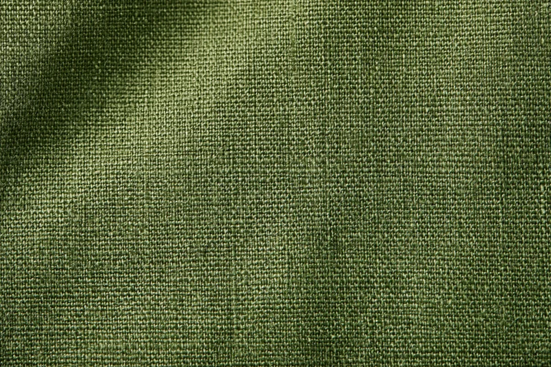 Close-up of olive green linen fabric with visible weave pattern filling the frame