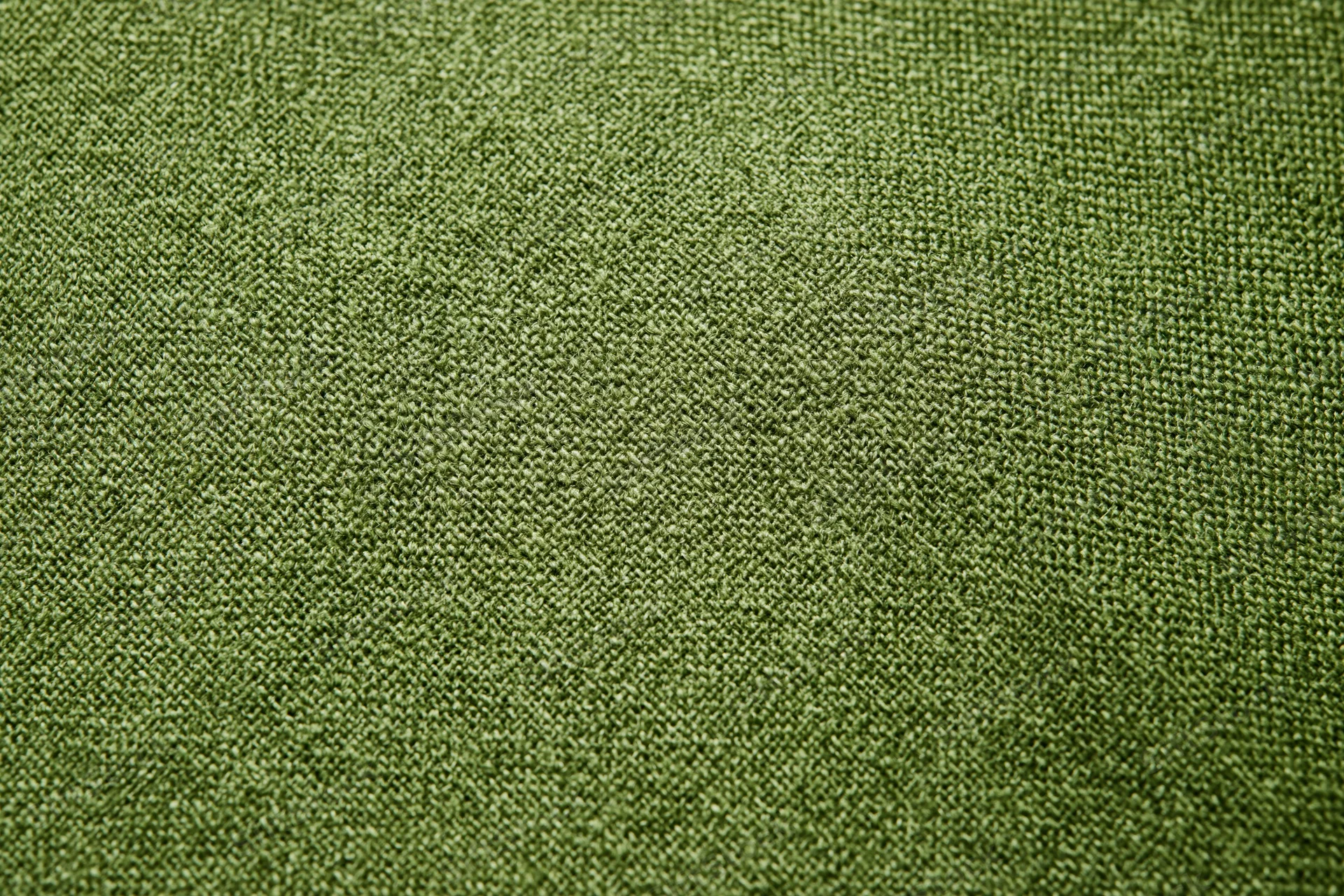 Close-up of olive green linen fabric with visible weave pattern filling the frame