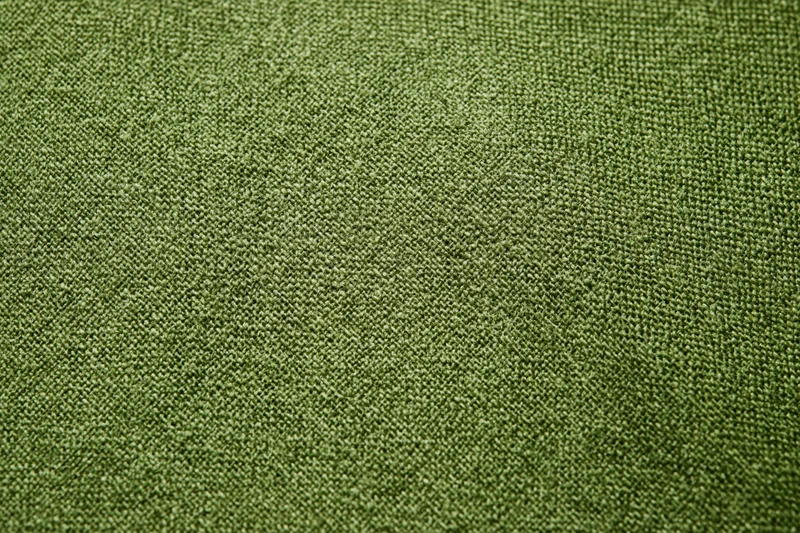 Close-up of olive green linen fabric with visible weave pattern filling the frame