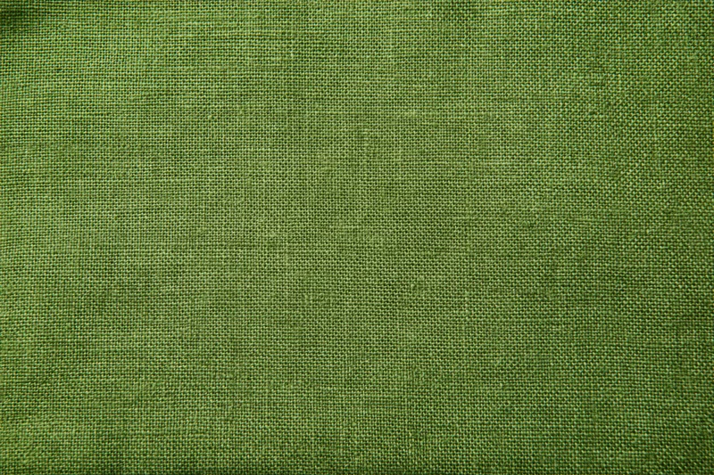 Close-up of olive green linen fabric with visible weave texture filling the frame