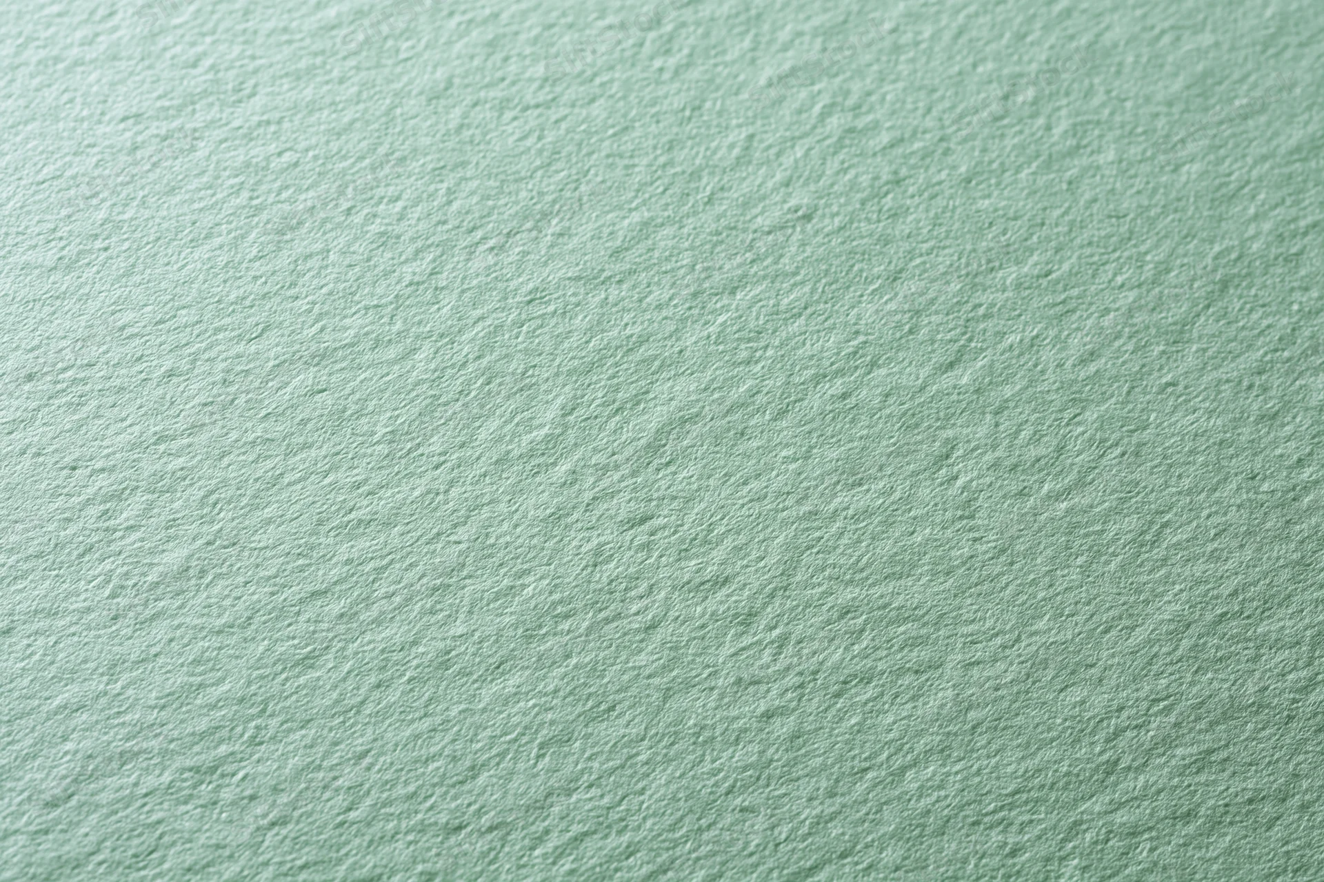 Close-up of pale mint green textured paper surface in flat lay arrangement