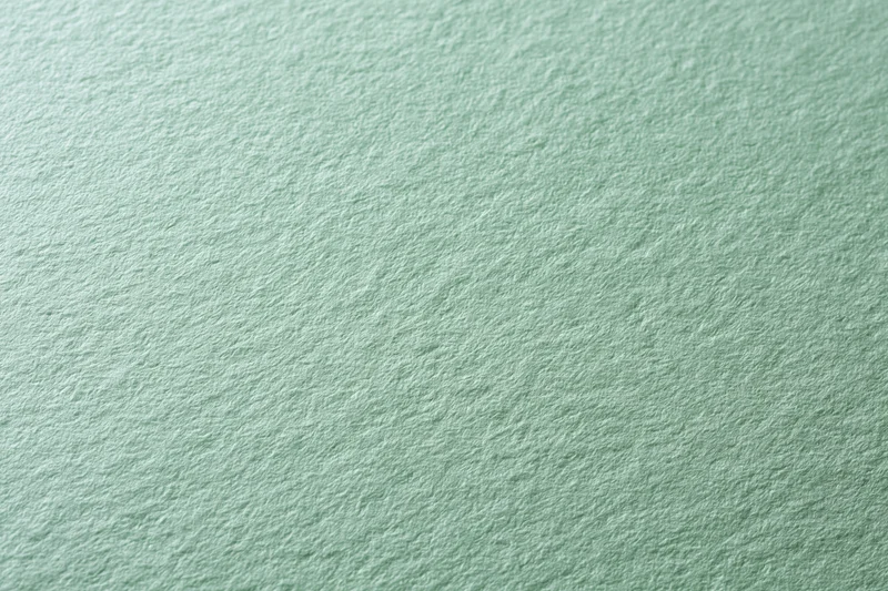 Close-up of pale mint green textured paper surface in flat lay arrangement