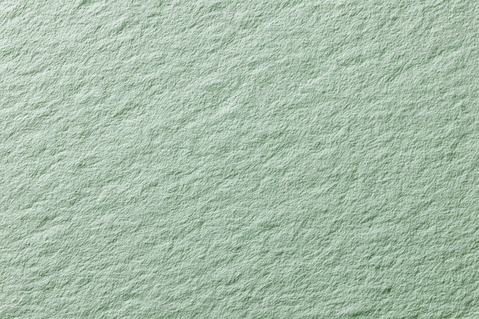 Close-up of pale mint green textured paper surface in flat lay arrangement
