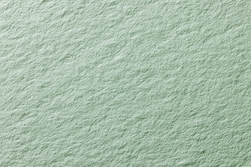 Close-up of pale mint green textured paper surface in flat lay arrangement