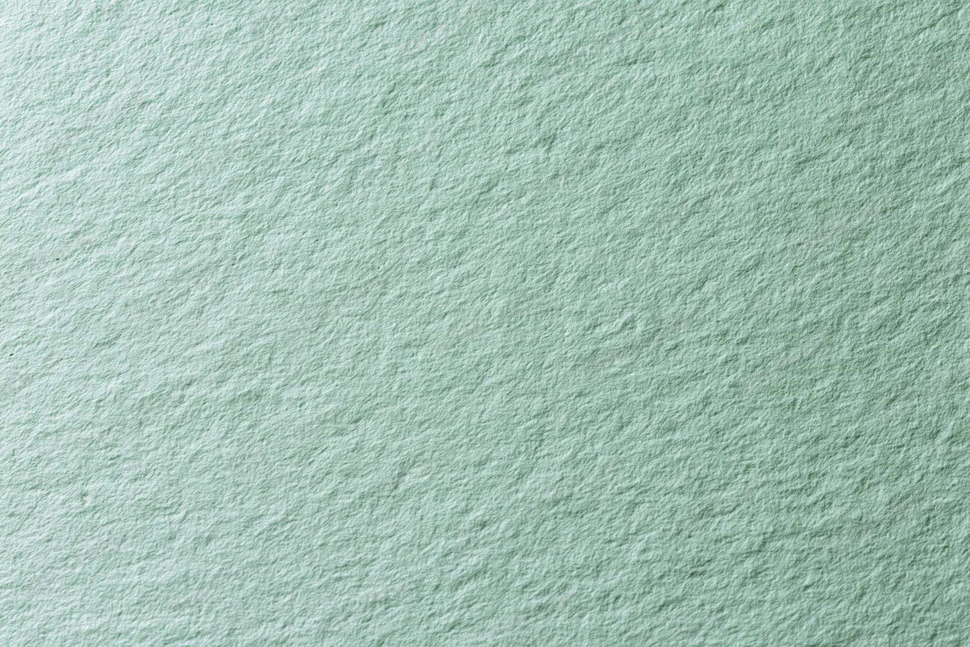 Close-up of pale mint green textured paper surface in flat lay arrangement
