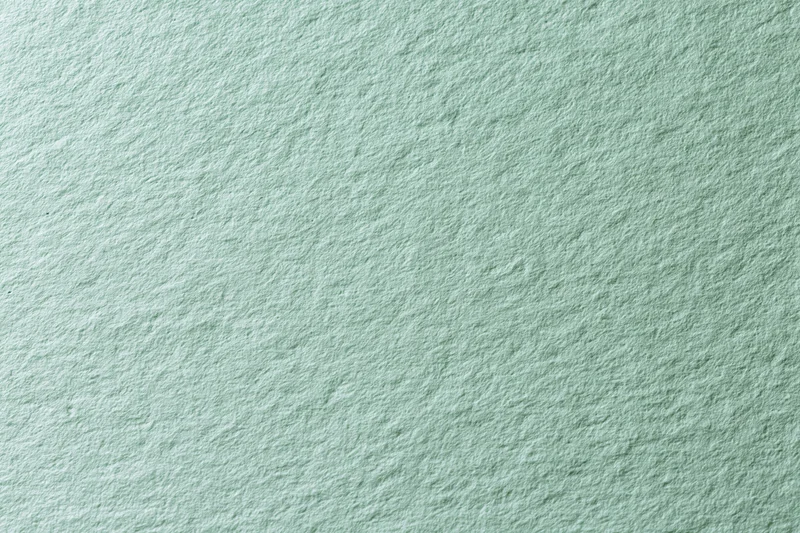 Close-up of pale mint green textured paper surface in flat lay arrangement