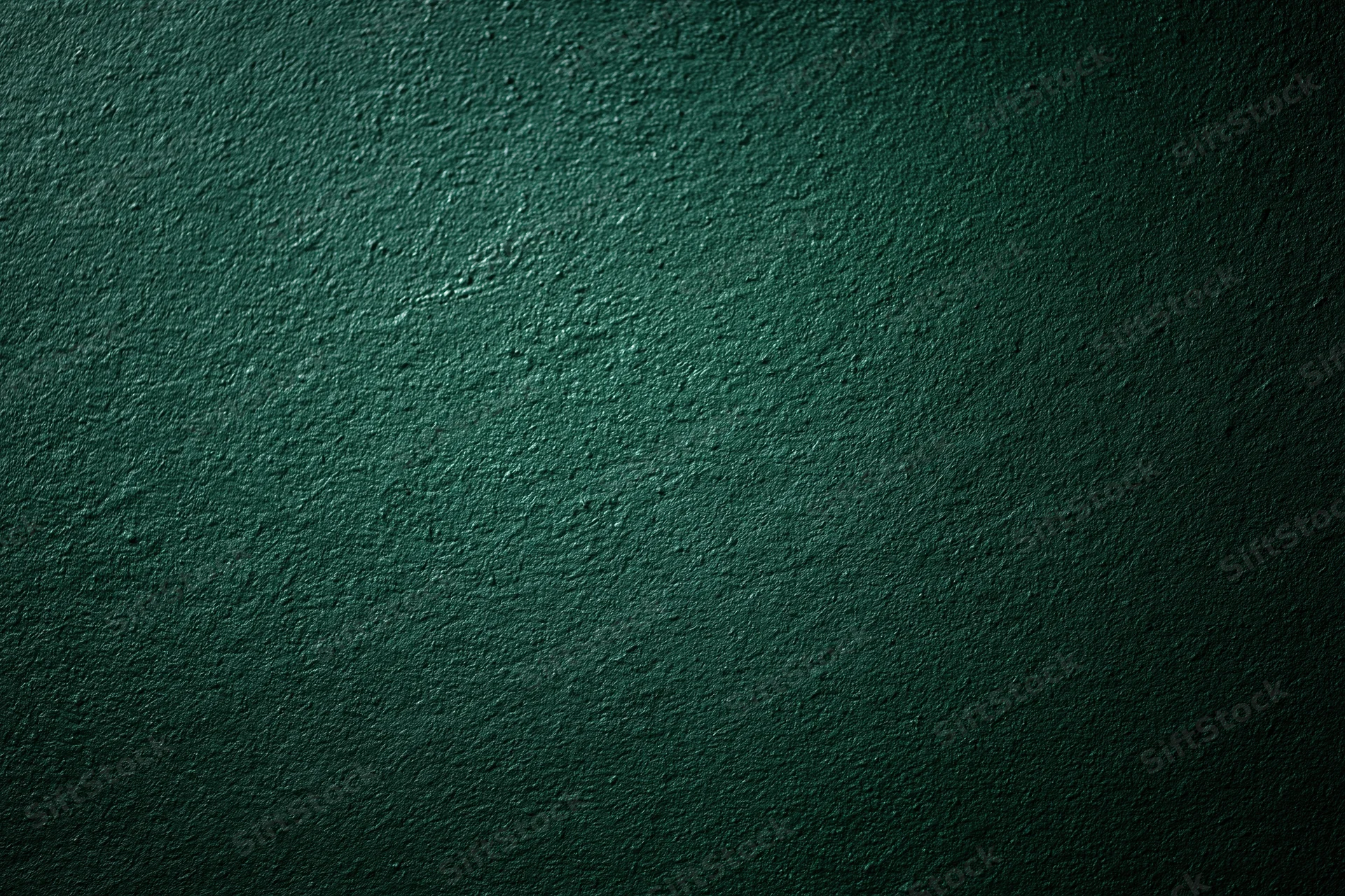 Close-up of dark forest green painted wall surface with textured finish