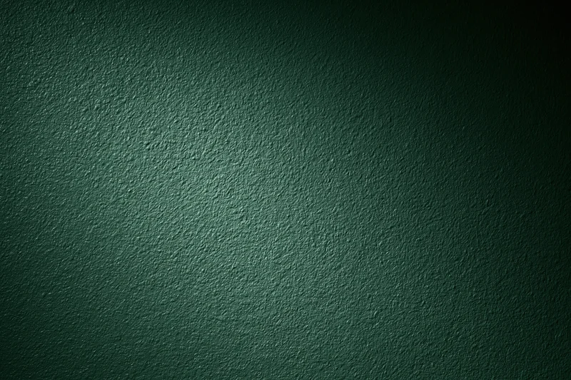 Close-up of dark forest green painted wall surface with textured finish