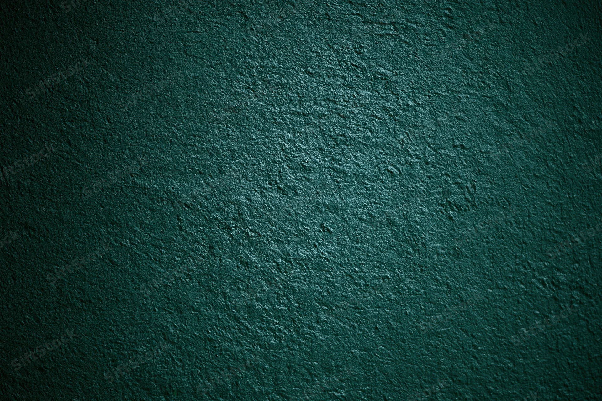 Close-up of dark forest green painted wall surface with textured finish