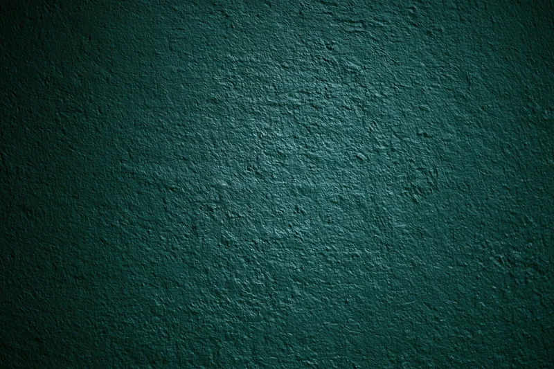 Close-up of dark forest green painted wall surface with textured finish