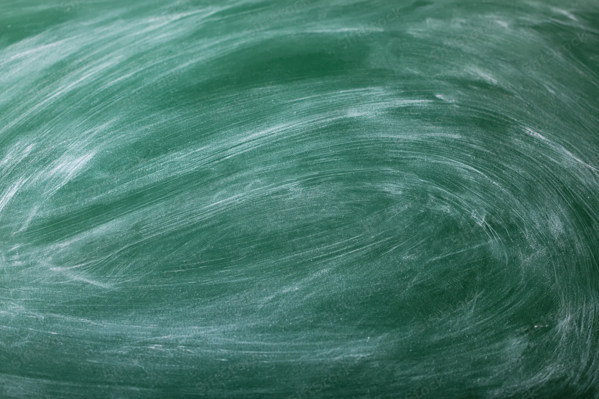 Close-up of a green chalkboard surface with smudged white chalk marks and swirl patterns from erasing