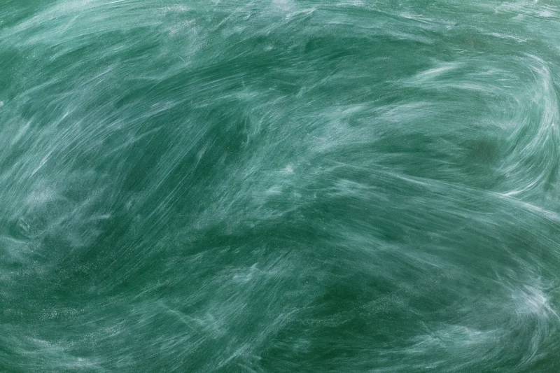 Close-up of a green chalkboard surface with smudged white chalk residue from recent erasing