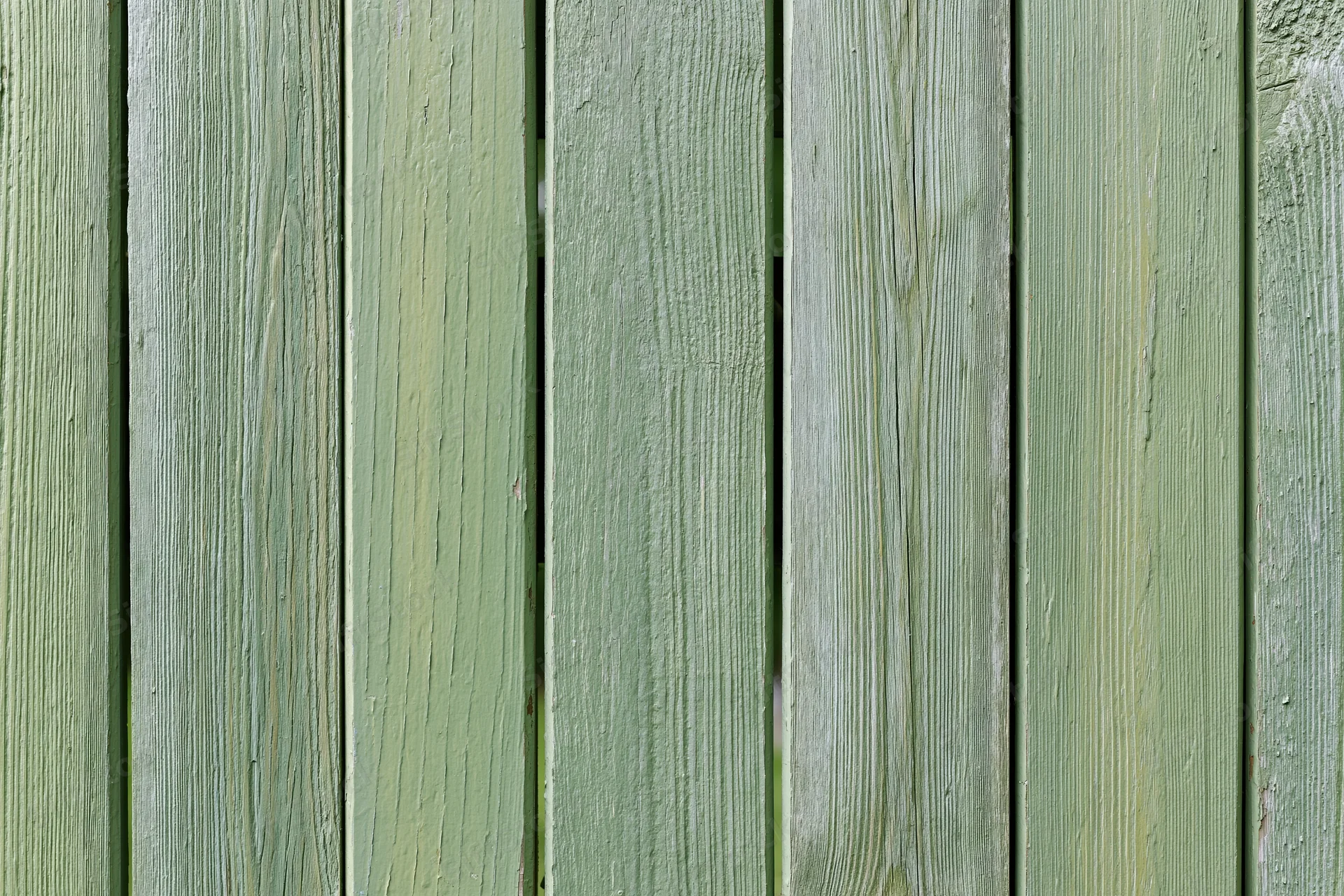Vertical weathered green wooden planks forming a garden fence surface