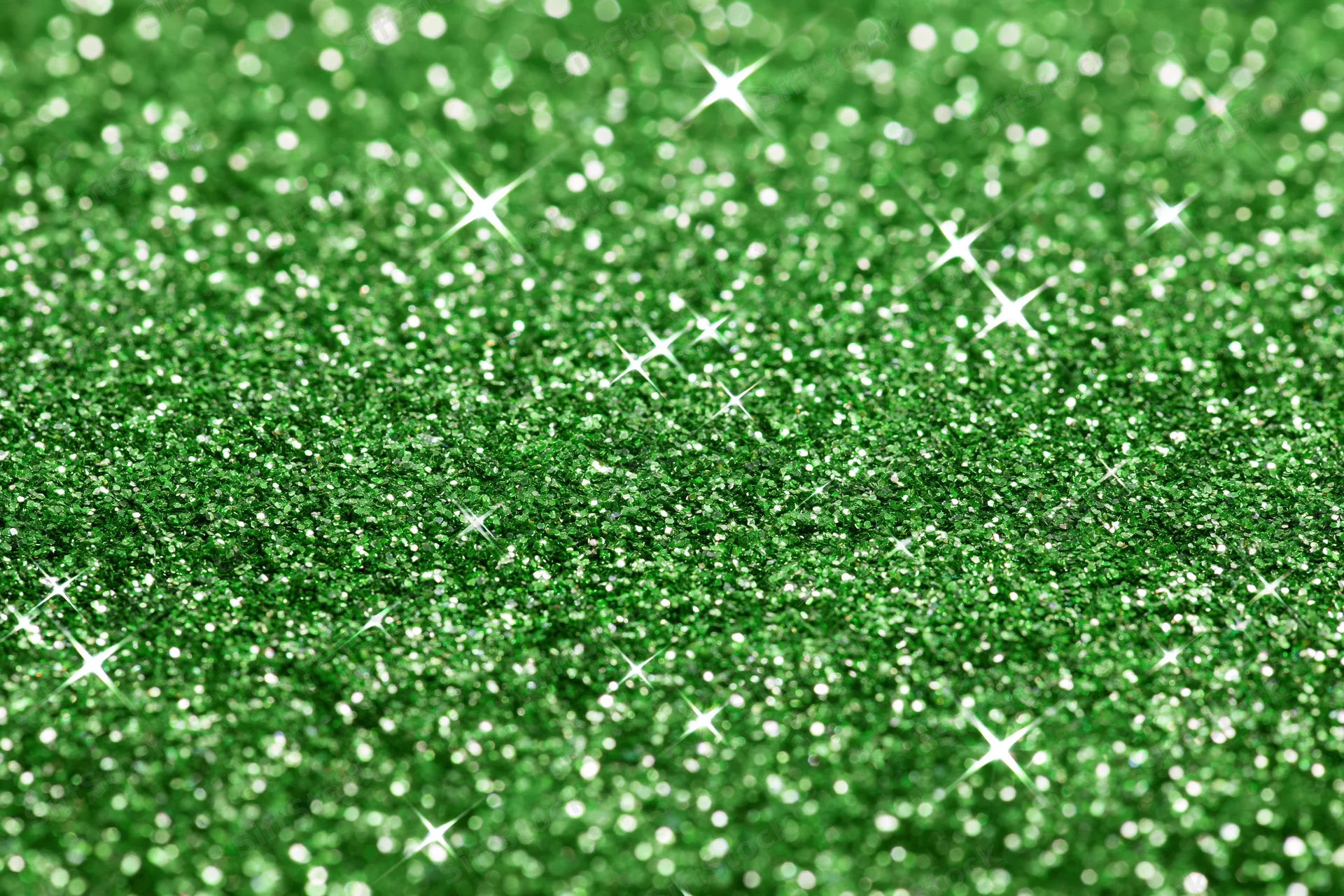 Close-up of bright green glitter surface with sparkling highlights filling the frame