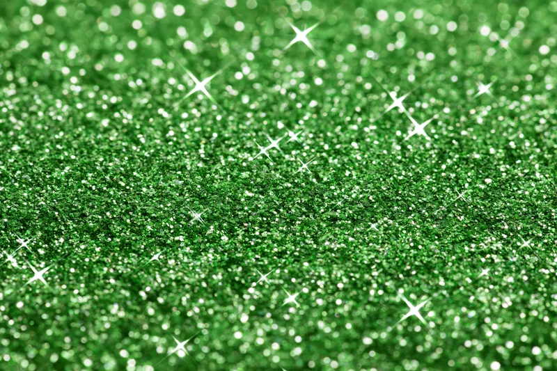 Close-up of bright green glitter surface with sparkling highlights filling the frame