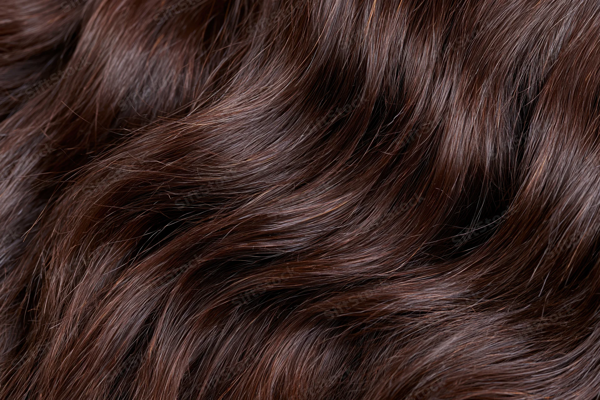 Close-up of dark brown wavy human hair filling the frame
