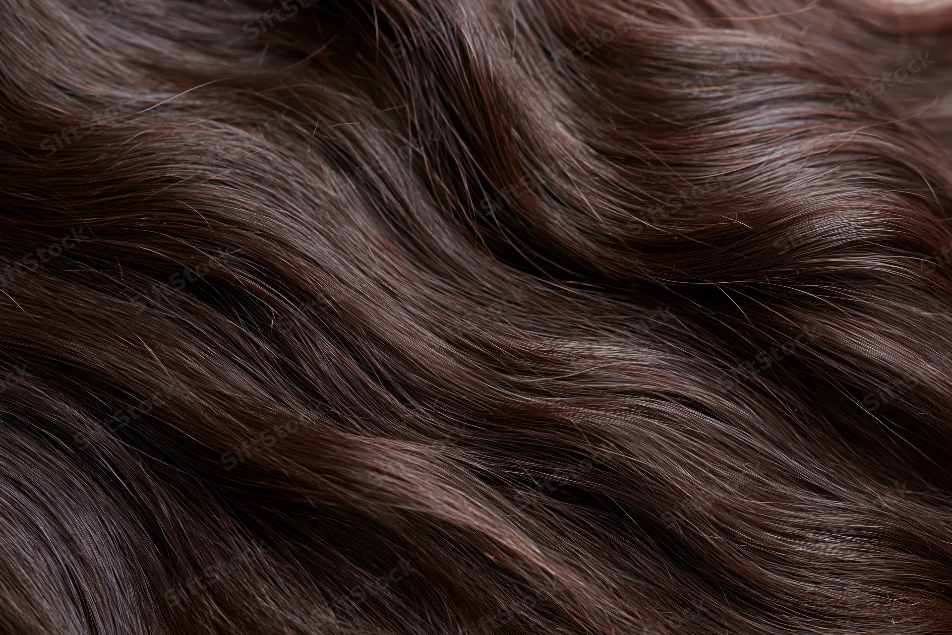 Close-up of dark brown wavy human hair filling the frame