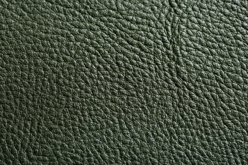 Close-up of dark forest green leather texture filling the frame