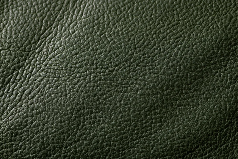 Close-up of dark forest green leather surface showing detailed grain texture