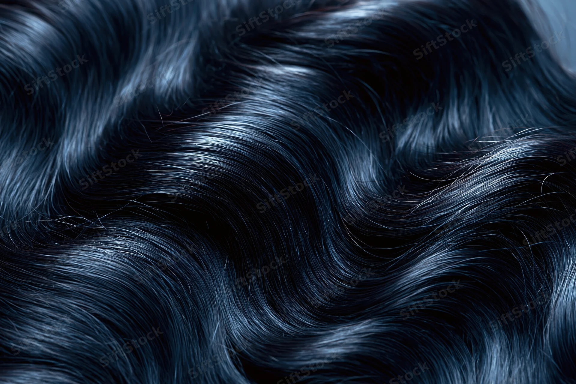 Close-up of glossy dark black wavy hair strands showing natural texture and shine