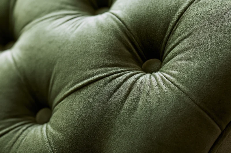 Close-up of tufted olive green velvet chesterfield sofa upholstery