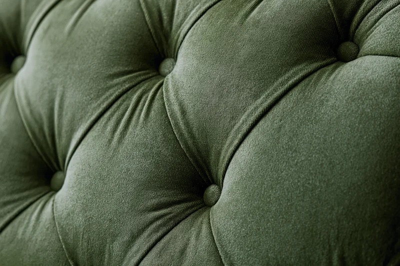 Close-up of olive green velvet tufted chesterfield sofa upholstery