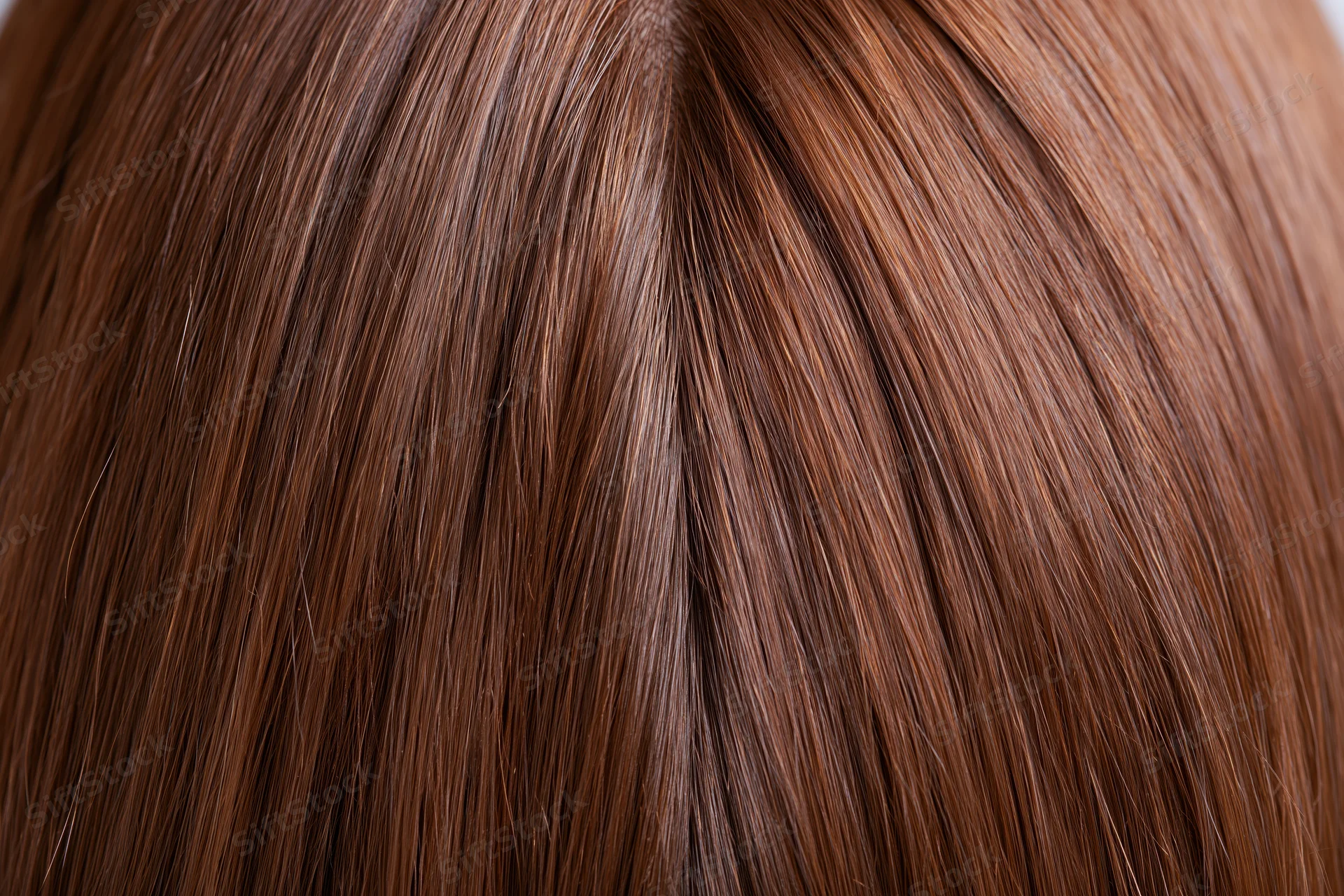Close-up of straight brown human hair with visible parting and texture