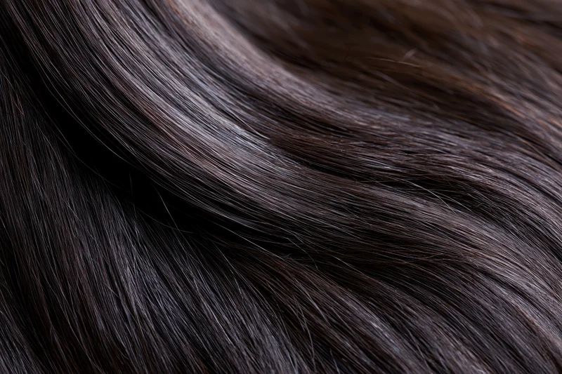 Close-up of straight dark brown-black hair strands showing smooth texture and glossy shine