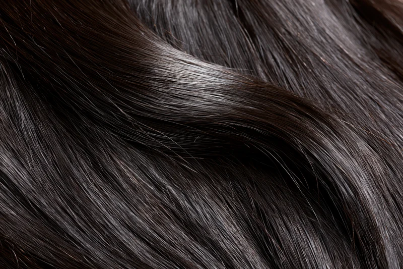 Close-up of straight dark brown-black hair strands showing smooth texture and glossy shine