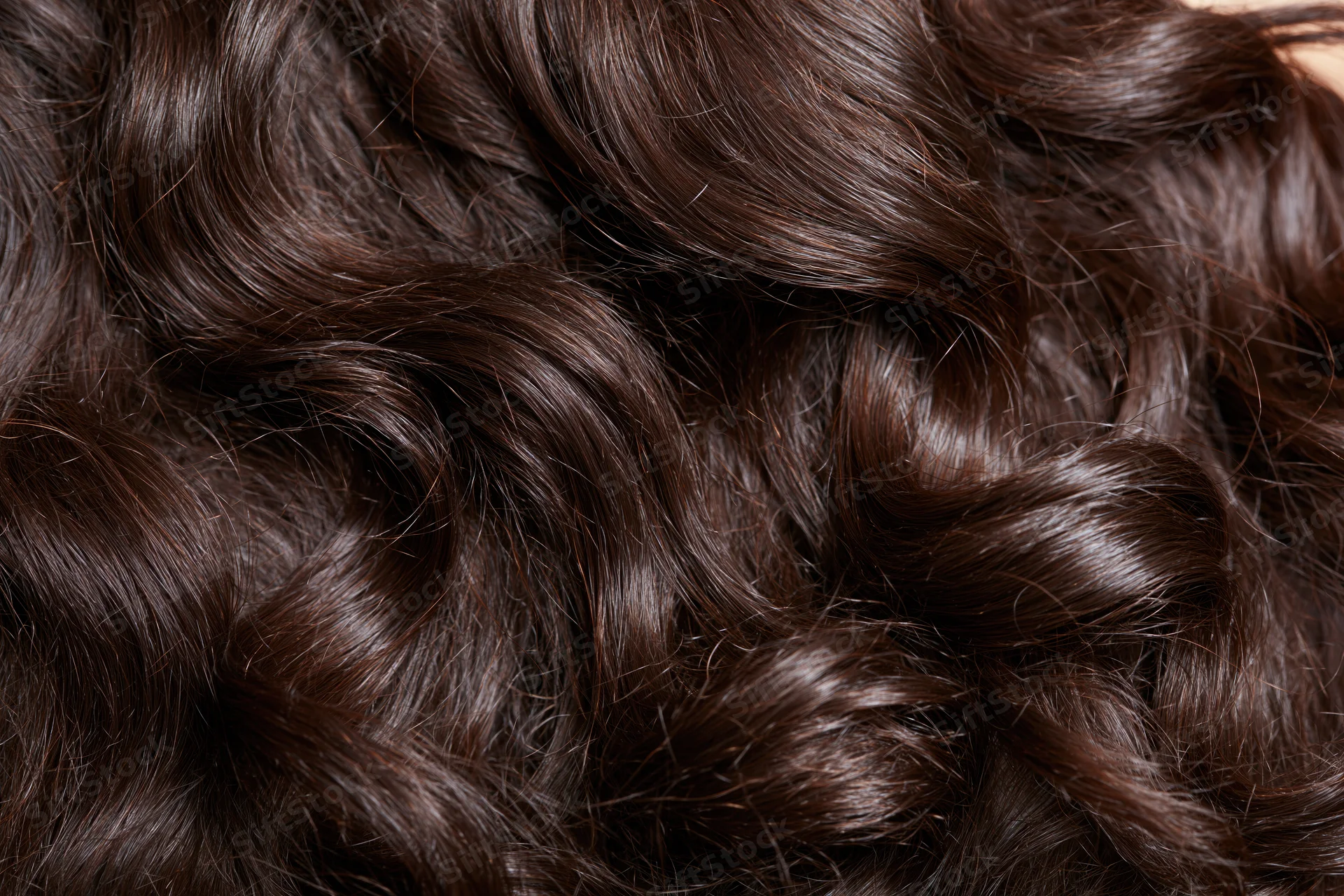 Close-up of thick dark brown wavy hair filling the frame