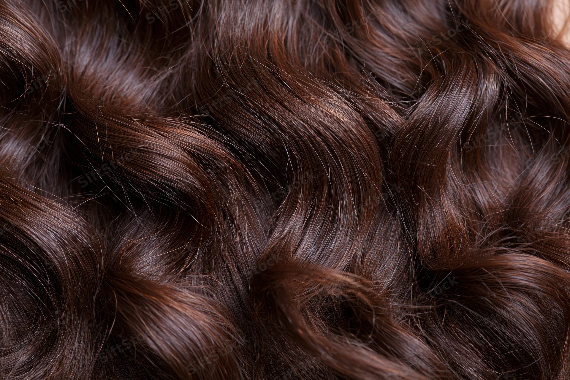 Close-up of thick dark brown wavy hair filling the frame